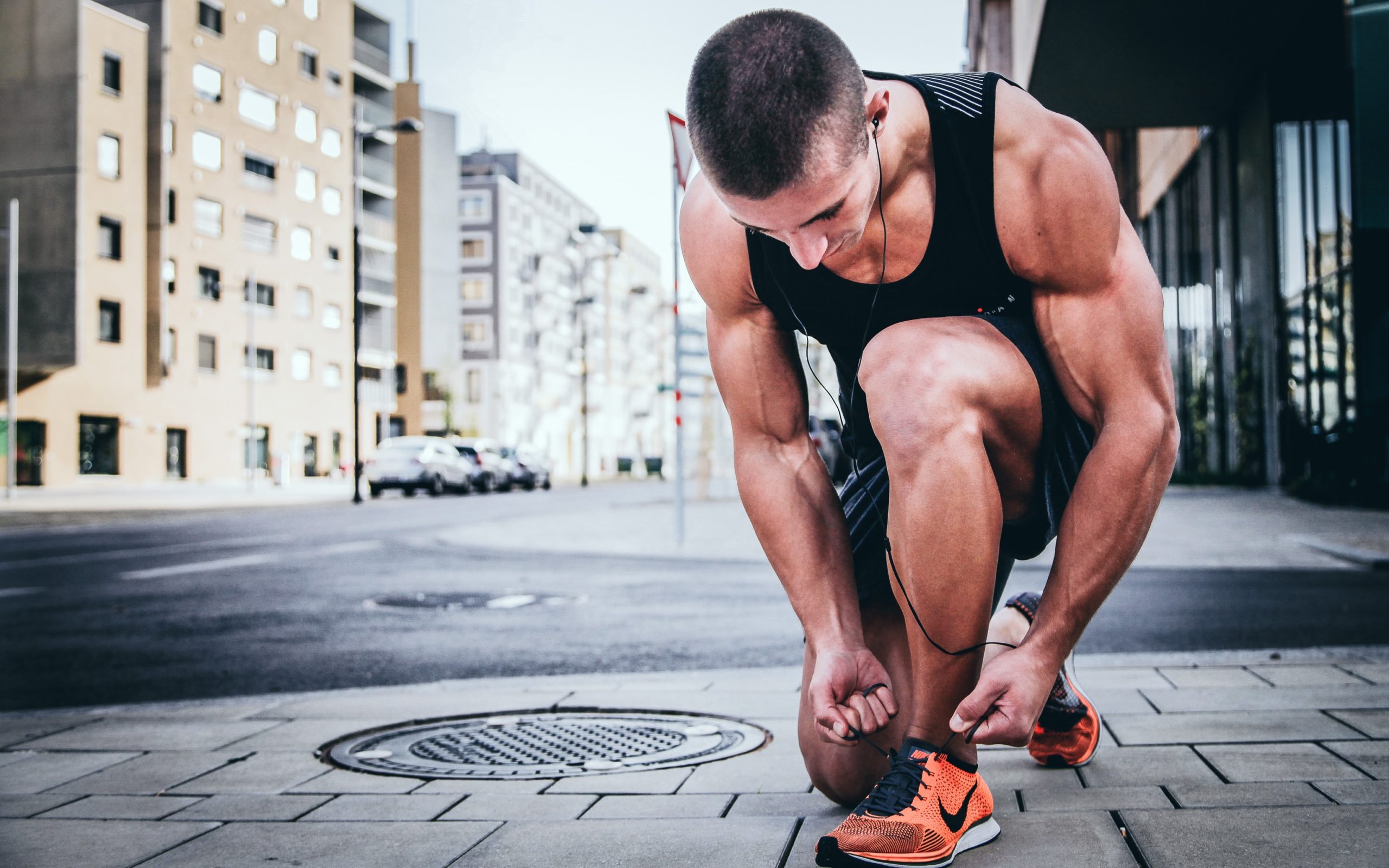Image of a runner tying his shoe.