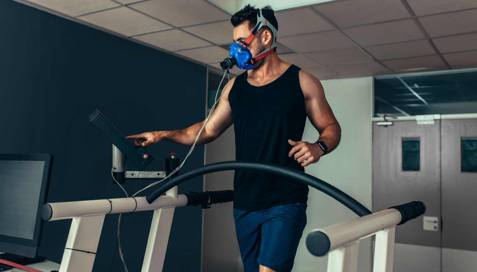 Image of a man undergoing exercise testing, wearing a face mask.