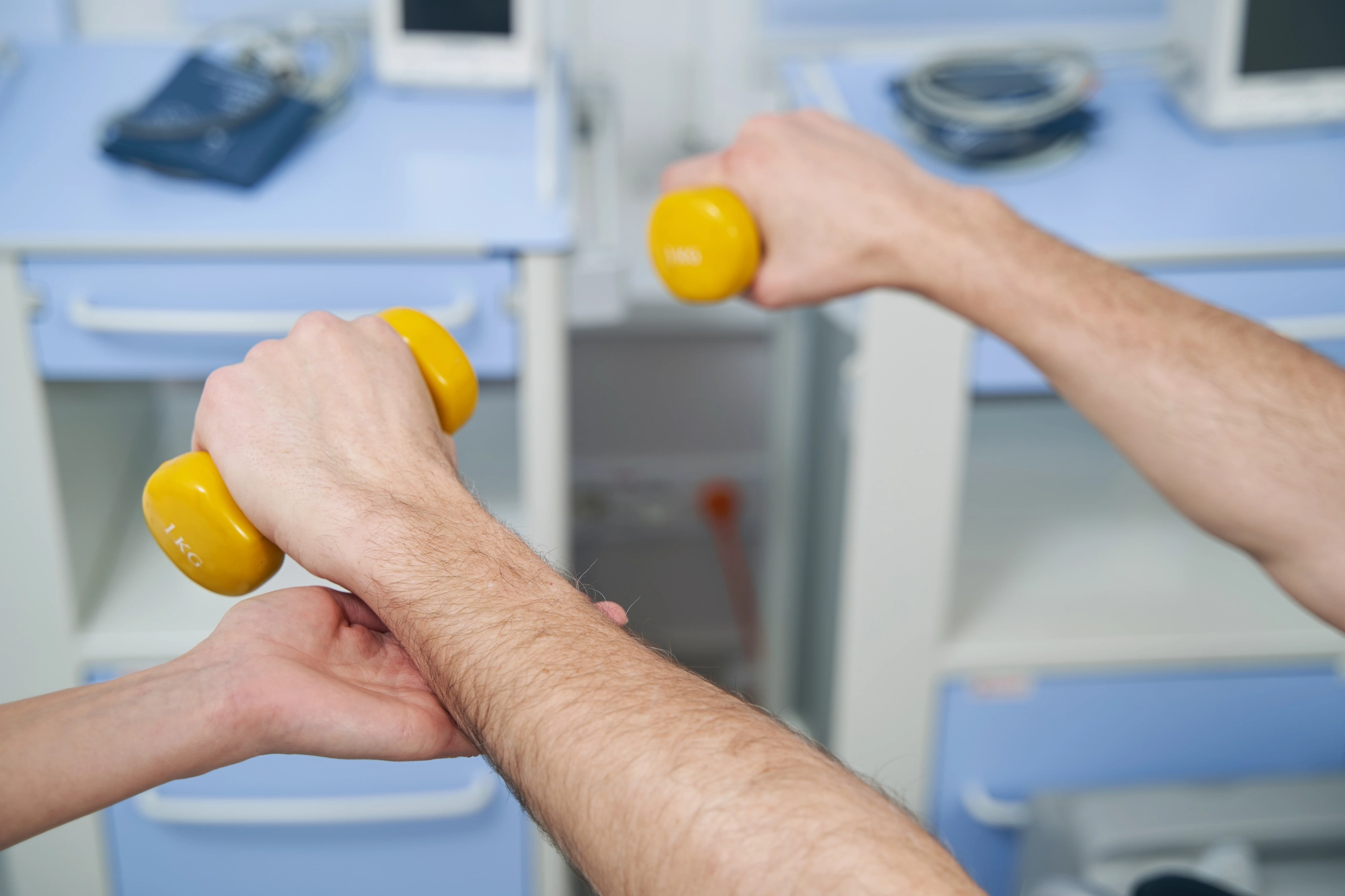 two arms holding yellow dumbbells.