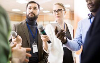 three journalists with microphones.