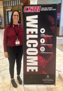 Dr. Candace Langston presenting on her dissertation topic at the College Sport Research Institute in Columbia, South Carolina, in March 2025.